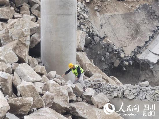 亂石林立、水流湍急，四川公路設(shè)計院工作人員不懼危險抵進觀察橋墩受損情況。四川公路設(shè)計院供圖